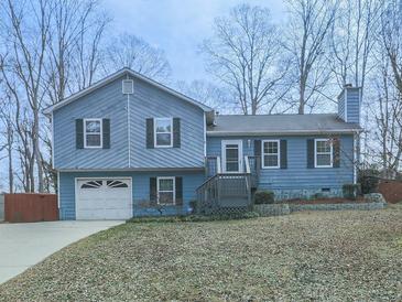 Charming home featuring a split level design, attached garage, and well-maintained front lawn at 1036 Pinetree Ct, Powder Springs, GA 30127