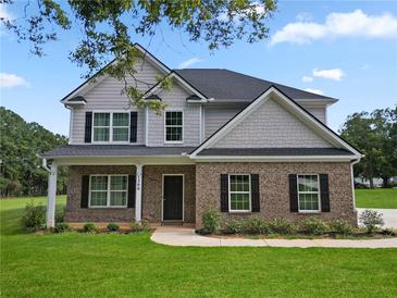 Charming two-story home with a brick facade, black shutters, a covered front porch, and a well-maintained lawn at 1300 Snapping Shoals Rd, Mcdonough, GA 30252