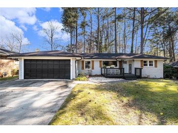Charming single-story home with a dark garage door, shutters, and a inviting front porch at 3331 Casa Linda Dr, Decatur, GA 30032
