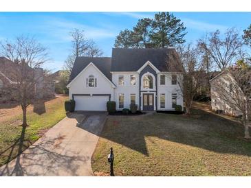 Charming two-story home with a well-manicured lawn, long driveway, and an attached two-car garage at 4275 Azalea Walk, Ellenwood, GA 30294