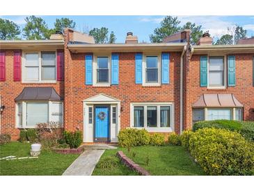 Charming brick townhome with colorful shutters and a well-maintained front lawn at 6105 Queen Anne Ct, Norcross, GA 30093