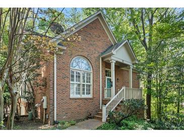 Charming brick home with a cozy front porch and well-maintained landscaping surrounded by mature trees at 31 Greenland Trce, Atlanta, GA 30342