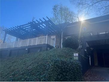 Home exterior boasting a pergola, lush landscaping, and dark paint at 294 Hascall Nw Rd, Atlanta, GA 30309