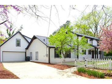 Charming white two-story home with a garage and a white picket fence surrounding the property at 270 Piedmont Ne Rd, Marietta, GA 30066