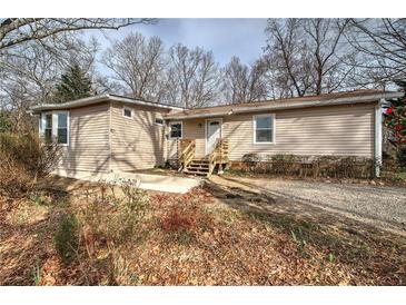 Charming single-story home with light beige siding and a welcoming front entrance with small wood stairs at 58 Knox Rd, Powder Springs, GA 30127