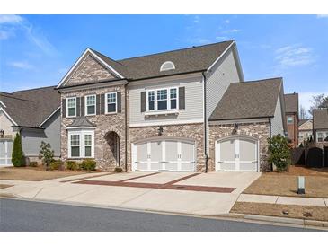 Beautiful two-story home featuring brick and siding, two-car garage, and well-manicured landscaping at 6180 Bellmoore Park Ln, Duluth, GA 30097