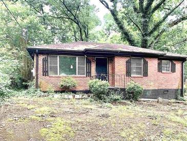 Charming brick home with a cozy, inviting front surrounded by mature trees at 2075 Dellwood Pl, Decatur, GA 30032
