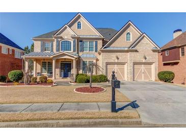 Beautiful two-story brick home with a manicured front yard and a two-car garage in a suburban neighborhood at 5732 Ashleigh Walk Dr, Suwanee, GA 30024