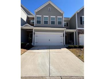 Charming townhome featuring a two-car garage, neutral siding, and well-manicured front yard at 501 Crescent Woode Dr, Dallas, GA 30157