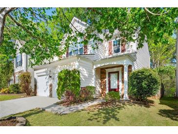 Charming two-story home with a well-manicured lawn, a two-car garage and beautiful trees in a suburban neighborhood at 3258 Welmingham Sw Dr, Atlanta, GA 30331