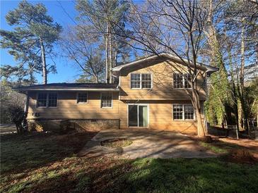 View of the home's backyard and exterior showing neutral siding and windows at 4820 Banner Elk Dr, Stone Mountain, GA 30083
