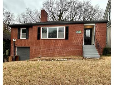 Charming red brick home with a chimney, black shutters, and an attached garage at 211 Wellington Sw St, Atlanta, GA 30314