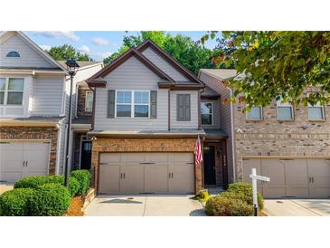 Charming townhome features a brick facade, two-car garage, and well-maintained landscaping at 2474 Whiteoak Se Run # 18, Smyrna, GA 30080