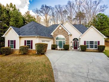 Charming single-story home featuring stone accents, an arched window, and a well-manicured front yard and driveway at 25 Cherokee Hills Dr, Rydal, GA 30171