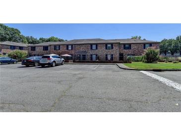 Apartment building with brick facade, blue shutters, and parking area at 3071 Colonial Way # J, Atlanta, GA 30341