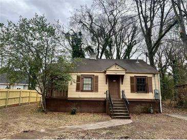 Charming one story home with brown shutters and a quaint covered porch, complemented by a neatly maintained front yard at 1458 Olive Sw St, Atlanta, GA 30310