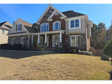 Charming two-story home with a combination of brick and stone facade and a well-manicured lawn at 838 Natchez Valley Ne Trce, Grayson, GA 30017