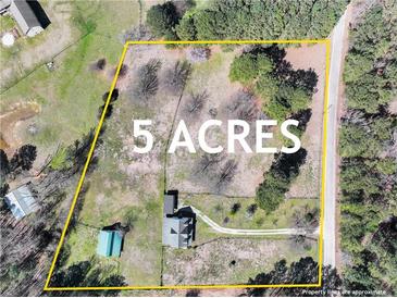 This aerial view showcases a sprawling 5-acre property, featuring a home, outbuildings, and lush greenery at 3121 Cox Cemetery Rd, Social Circle, GA 30025