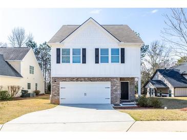 Charming two-story home featuring a brick facade, white siding, and a spacious driveway at 9122 Golfview Cir, Covington, GA 30014