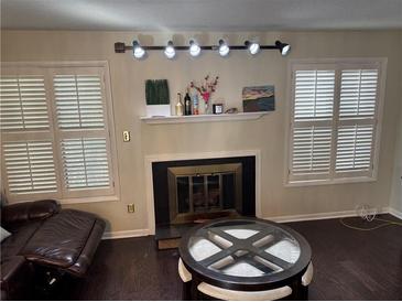 Inviting living room featuring a fireplace, plantation shutters, and stylish decor at 1110 Country Ct, Lawrenceville, GA 30044