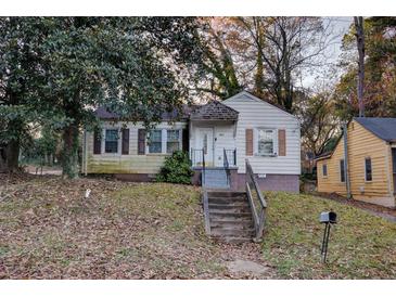 Quaint home features a cozy front yard with mature trees and a classic exterior, perfect for a starter home at 1347 Westmont Sw Rd, Atlanta, GA 30311