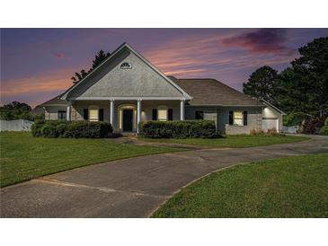 Charming one-story home boasts mature landscaping and a welcoming front porch at 950 Sundew Se Dr, Conyers, GA 30013