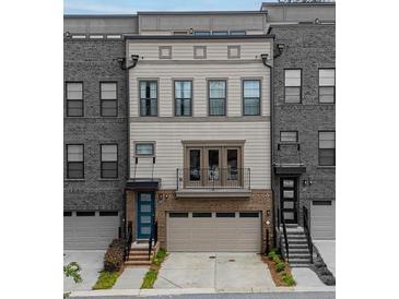 Charming three-story townhouse with brick and neutral siding, featuring a balcony and attached garage at 1049 Brandsford Nw St # 27-01, Atlanta, GA 30318