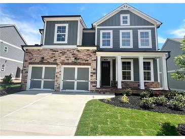 Charming two-story home with stone accents, a two-car garage, and a well-manicured lawn at 316 Willow Cv, Canton, GA 30114