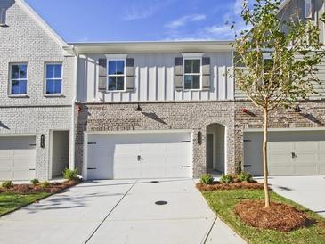 Charming townhome exterior featuring brick accents, white garage doors, and well-maintained landscaping at 4655 Larkfield Way, Powder Springs, GA 30127