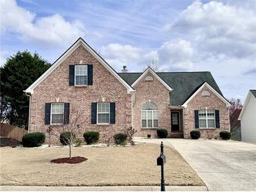 Charming brick home featuring a well-manicured lawn and traditional architectural details at 3345 Stoneleigh Run Dr, Buford, GA 30519
