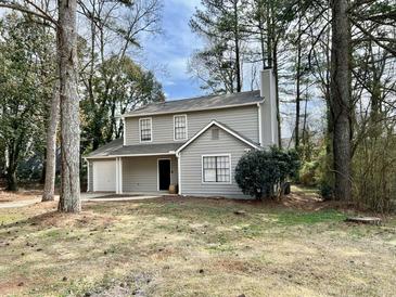 Charming two-story home with neutral siding, attached garage and mature trees at 5463 Forest East Ln, Stone Mountain, GA 30088