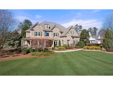 Beautiful two-story home featuring stone and shake siding, lush landscaping, and a well-manicured lawn at 5120 Parkwood Oaks Ln, Smyrna, GA 30126