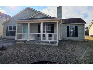 Charming single-story home featuring a covered front porch and manicured lawn at 5778 Eagles Feather Ln, Riverdale, GA 30274