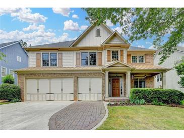 Beautiful two-story home with a brick and siding exterior, three-car garage, and well-manicured front lawn at 3305 Suffolk Dr, Cumming, GA 30041