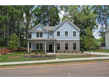 Charming two-story home featuring a covered porch and professionally landscaped front yard at 4524 Ajo Walk, Atlanta, GA 30331