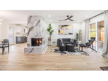 Bright living room featuring a marble fireplace, modern furniture, and large windows for plenty of natural light at 3388 Hyland Dr, Decatur, GA 30032