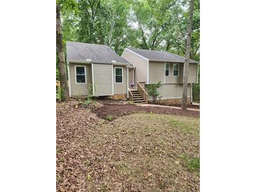 Charming home featuring a neutral palette, newer windows, and lush landscaping with a stone foundation at 6739 Valley Ct, Douglasville, GA 30135