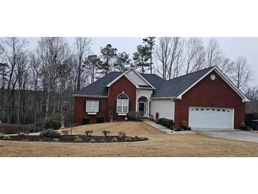 Charming brick home with a well-manicured lawn and attached two car garage at 70 Trelawney Cir, Covington, GA 30016