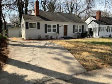 Charming single-Gathering home featuring a concrete driveway, well-kept lawn, and a detached garage at 1132 Fair St, Atlanta, GA 30314