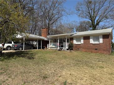 Charming single-story brick home featuring a covered front porch and a convenient carport at 459 N Norcross Tucker Rd, Norcross, GA 30071