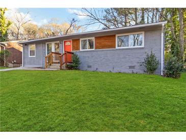 Charming gray brick home featuring a bright orange front door and a well-maintained green lawn at 1894 Evans Sw Dr, Atlanta, GA 30310