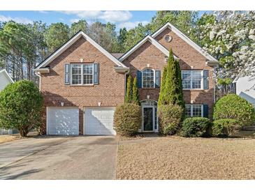 Charming two-story brick home with well-manicured landscaping and an inviting double garage at 217 Park Creek Dr, Woodstock, GA 30188