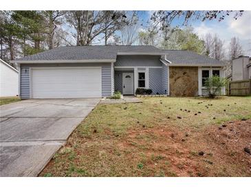 Charming home with a two-car garage, stone accents, and a well-maintained front lawn at 4938 Terrace Green Trce, Stone Mountain, GA 30088