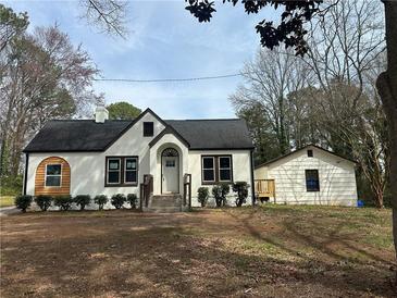 Charming home with white painted brick and dark trim, complemented by mature trees at 684 S Hairston Rd, Stone Mountain, GA 30088