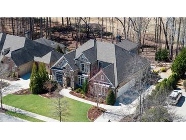 Beautiful home featuring stone accents, multiple garage spaces, mature landscaping, and a circular driveway at 78 Cuthbert Ln Ne, Acworth, GA 30101