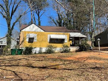 Charming yellow home featuring awnings, covered porch, and mature trees at 1722 Terry Mill Se Rd, Atlanta, GA 30316