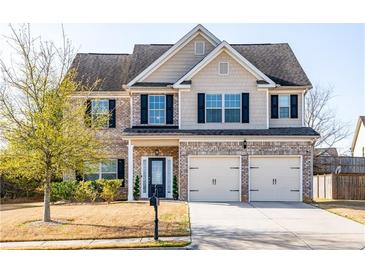 Charming two-story home with brick and siding, two-car garage, and well-manicured front yard at 2436 Planters Mill Way, Conyers, GA 30012