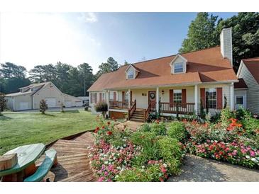 Charming home featuring a landscaped front yard with a covered porch and red shutters at 2585 Braselton Hwy, Buford, GA 30519