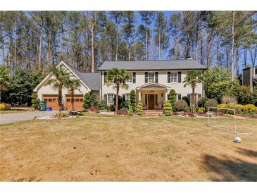 Charming home with a well-kept lawn, mature landscaping, and a welcoming front porch at 4970 Lakeland Woods Ct, Atlanta, GA 30338