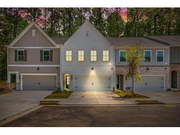 Charming townhome with a two-car garage, freshly manicured lawn, and inviting curb appeal at 1624 Ruskin Way, Marietta, GA 30062